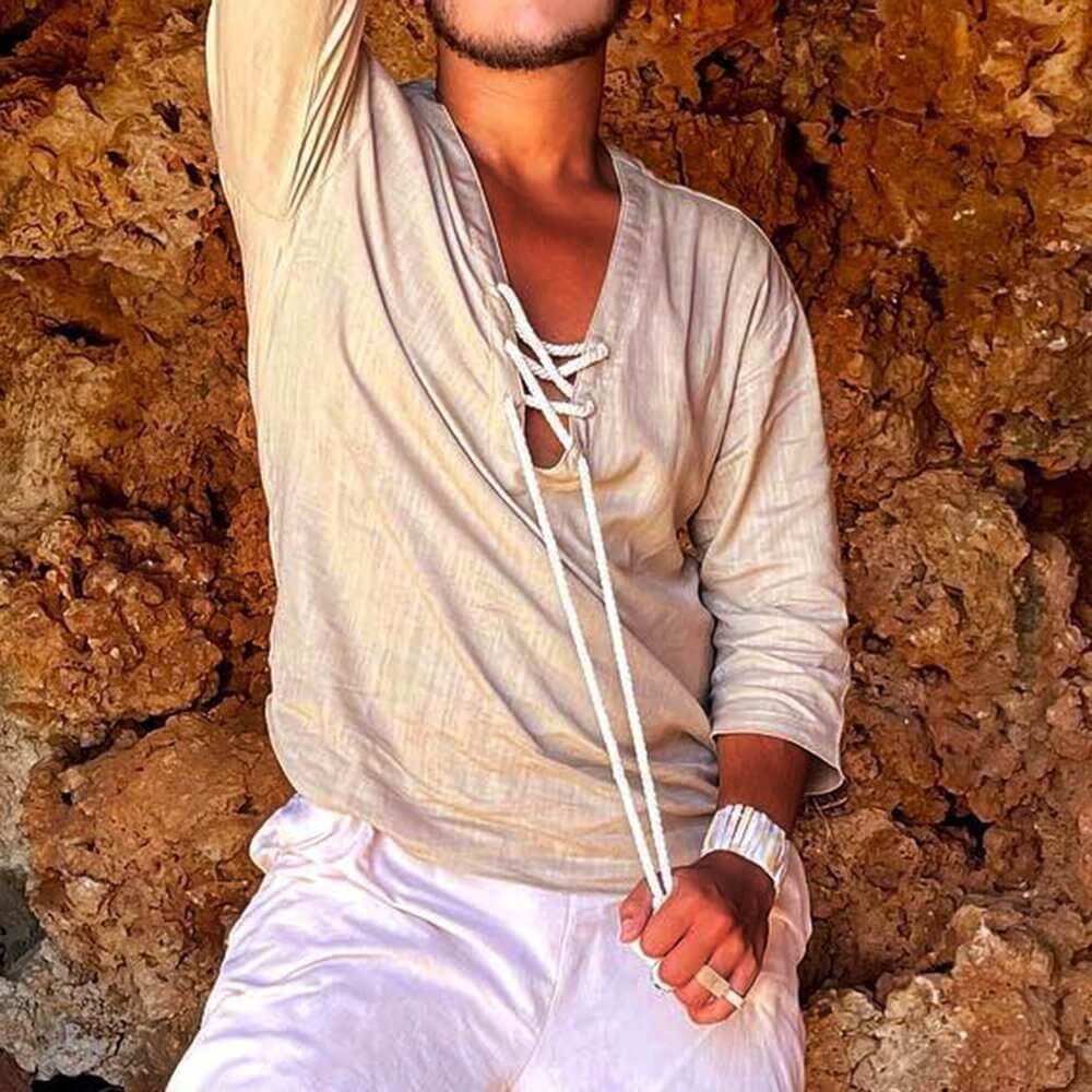 Fashion-forward individual wearing a beige lace up t-shirt with white drawstrings, styled casually against a rocky background.