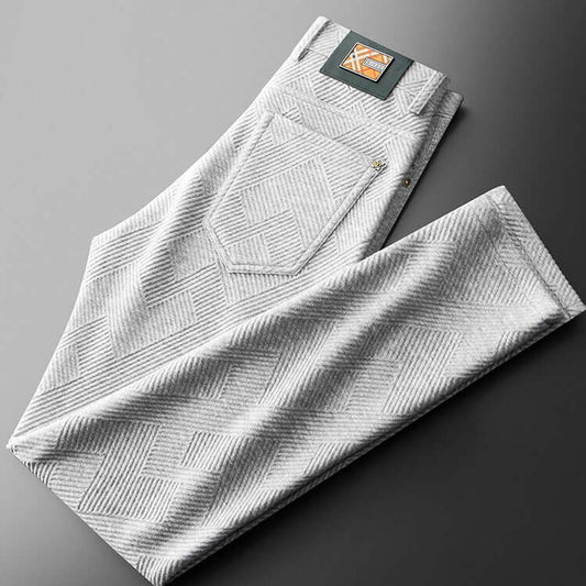 Stylish jacquard trousers folded on a gray background, showcasing intricate pattern and modern design for versatile wear.