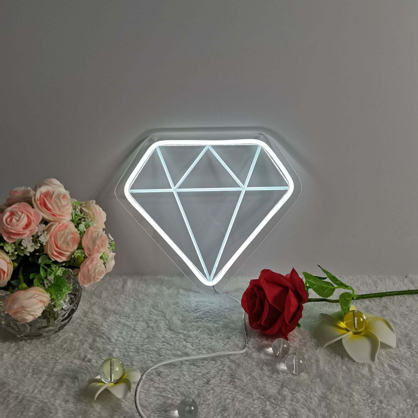 Stylish diamond-shaped LED night light beside flowers, enhancing cozy home decor.
