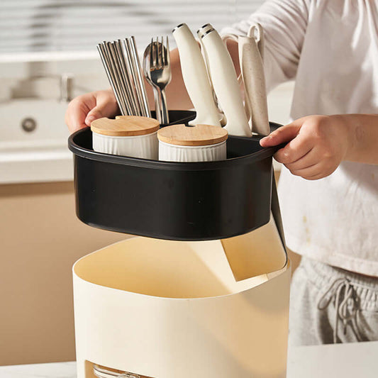 Person organizing kitchen utensils in a stylish black storage box set for a clutter-free cooking space.
