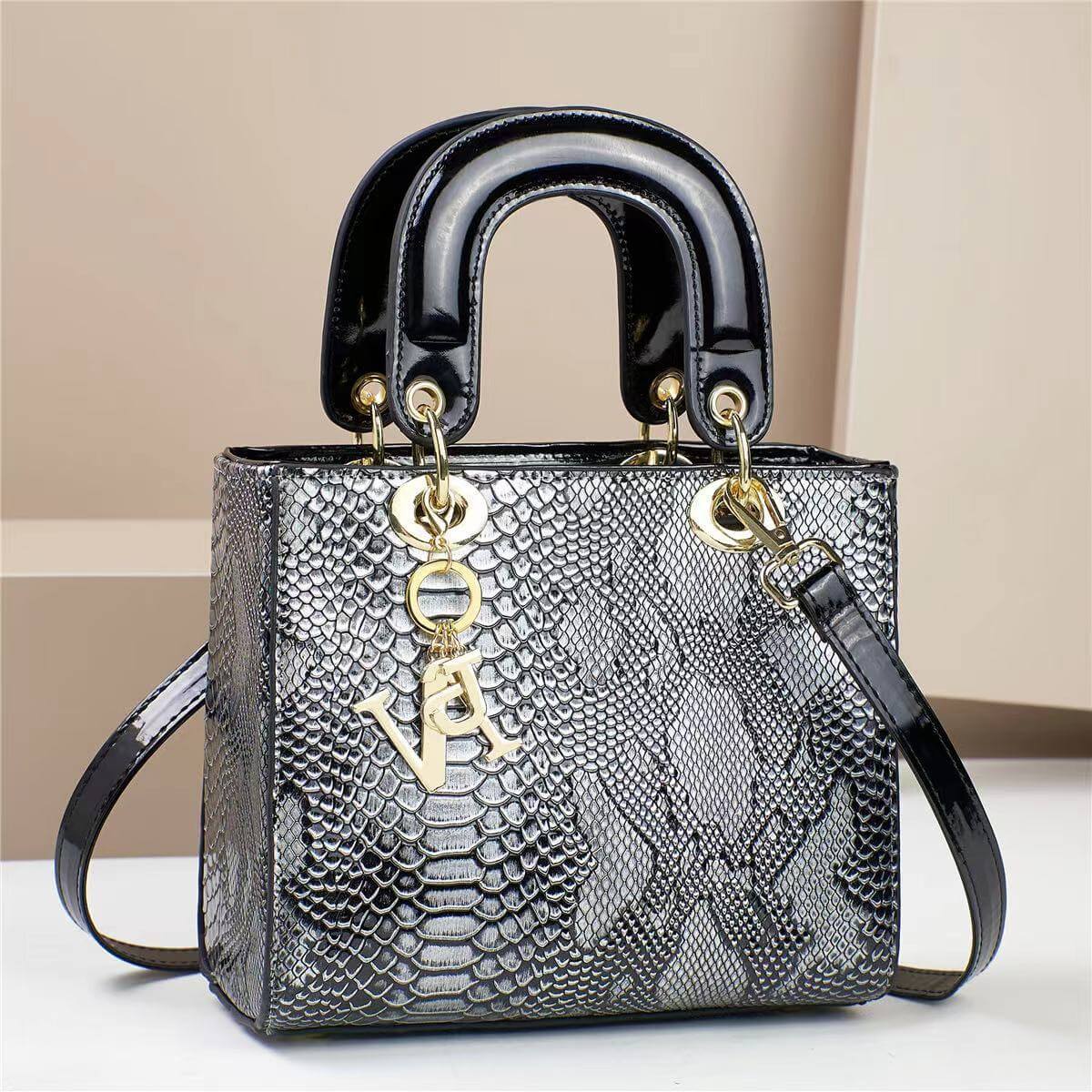 Elegant snakeskin-patterned handbag with black handles and gold accents, designed for modern fashion enthusiasts.