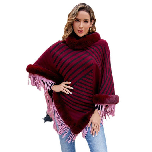 Stylish woman wearing a Poncho Coat with Fur, featuring bold stripes and fringed edges for a chic look.