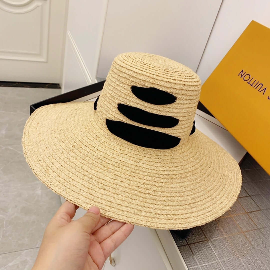 Stylish raffia big brim hat with black accents, perfect for summer outings and sun protection.