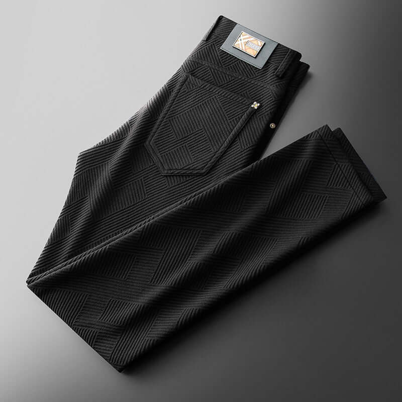 Black Jacquard Trousers showcasing elegant pattern, perfect blend of style and comfort for modern men, folded on a gray surface.