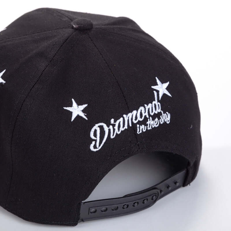 Black flat brim cap with embroidered stars and 'Diamond in the Sky' design on the back, featuring adjustable strap.