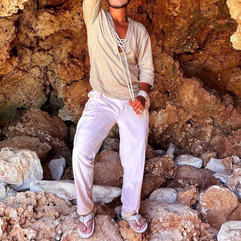 Fashionable lace up T-shirt paired with white pants, perfect for casual outings or relaxing at home, worn in a rocky natural setting.