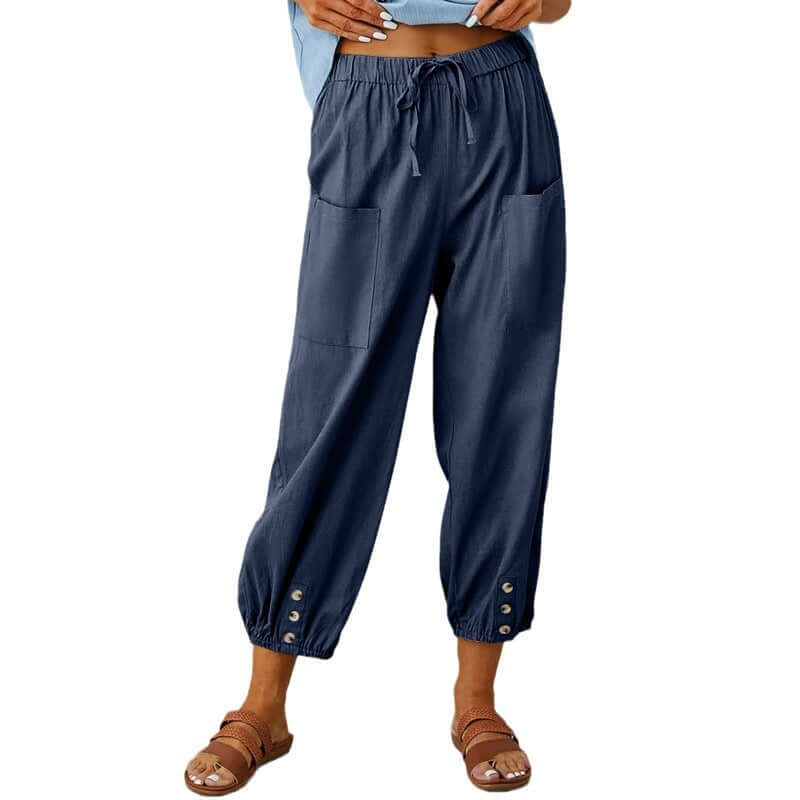Fashionable navy blue ladies linen trousers with pockets, showcasing relaxed fit and buttoned cuffs, perfect for breathable comfort.