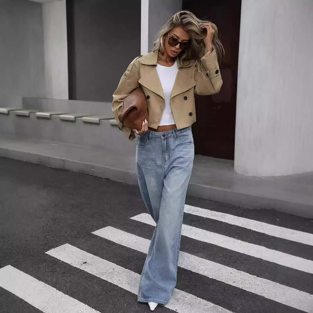 Fashionable woman in khaki Ladies Casual Blazer and jeans walking across street, showcasing modern fall style with confidence.