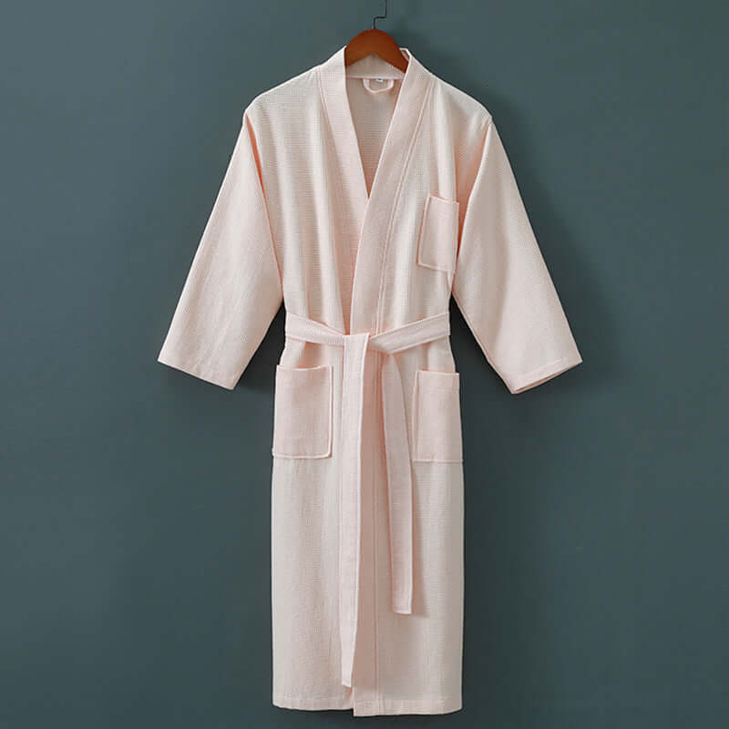 Luxurious unisex spa robe featuring cotton and mink hair fabrics, hanging on a wooden hanger against a dark background.