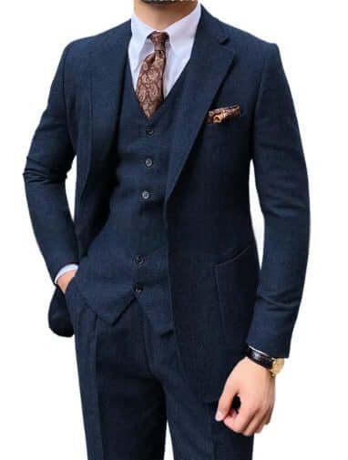 Man wearing a sophisticated 3-piece herringbone suit, highlighting modern style and elegance. Perfect for versatile occasions.