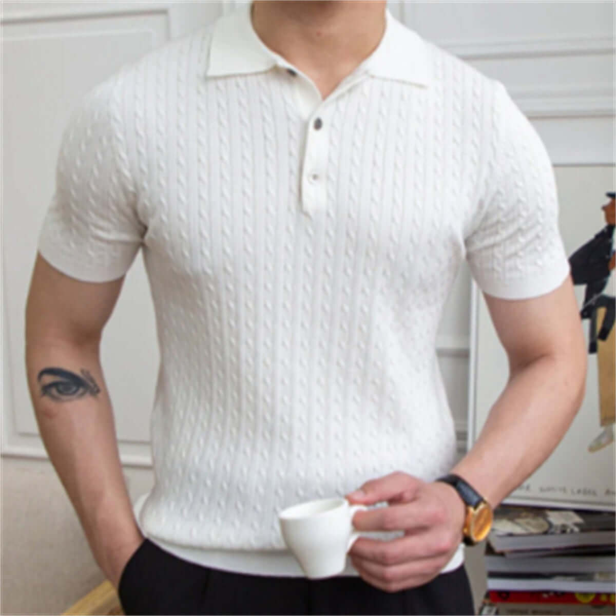 Man wearing a white short-sleeved polo shirt with textured design, ideal for casual outings, holding a cup, showcasing relaxed style.