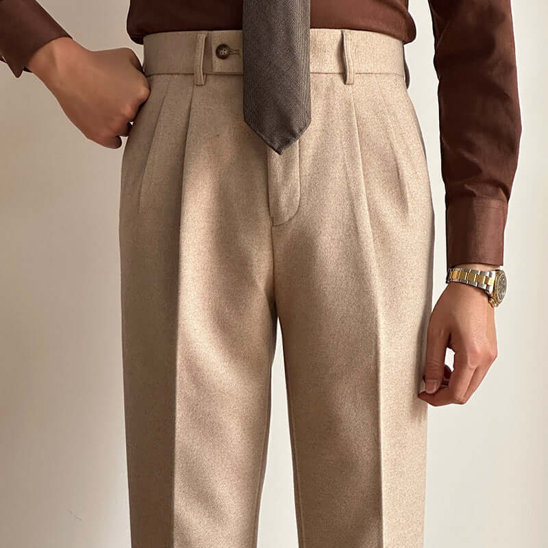 Man wearing stylish beige suit slacks with brown shirt and tie, showcasing modern and versatile fashion for formal and casual occasions.