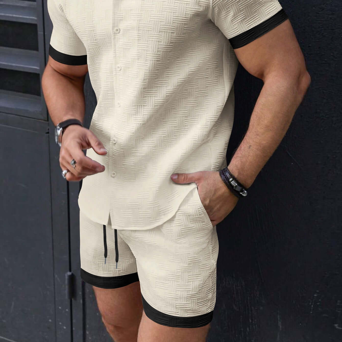 Man wearing stylish men's beach attire shorts and matching shirt in a casual outdoor setting.