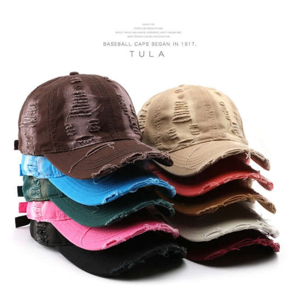 Stack of colorful Worn Out Caps showcasing distressed design, perfect for a casual and trendy style upgrade.
