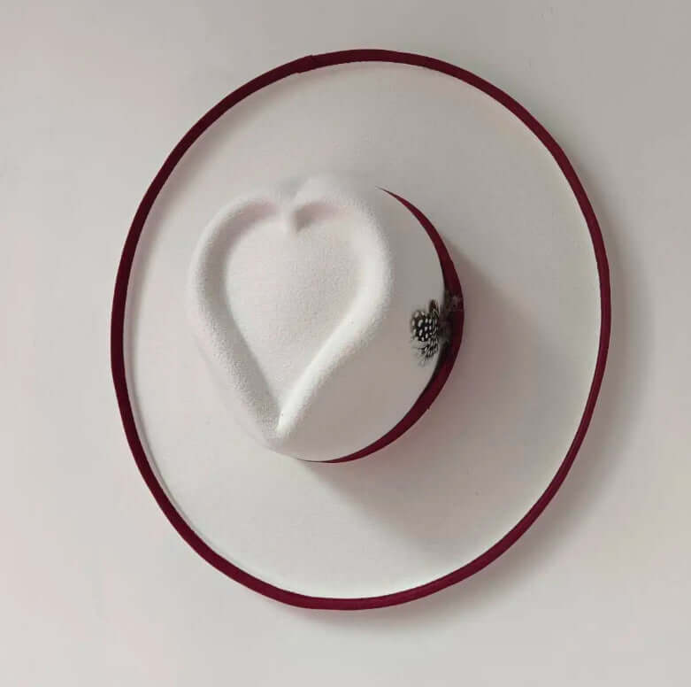 White Heart Hat with red trim and decorative embellishments, made from high-quality woolen materials for warmth and style.