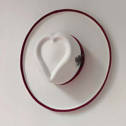White Heart Hat with red trim and decorative embellishments, made from high-quality woolen materials for warmth and style.