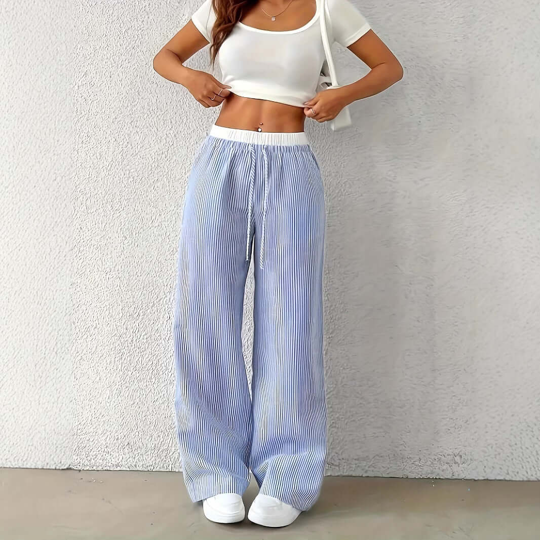 Woman wearing Ladies Stripe Trousers in light blue, showcasing a stylish straight-leg design against a neutral background.