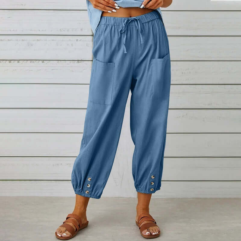 Woman wearing blue Ladies Linen Trousers with pockets and button details, showcasing comfortable and stylish design.
