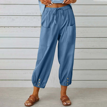 Woman wearing blue Ladies Linen Trousers with pockets and button details, showcasing comfortable and stylish design.