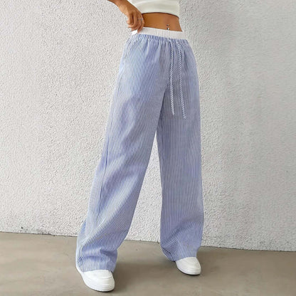 Woman wearing blue Ladies Stripe Trousers with white vertical stripes, showcasing high-quality polyester and stylish design.