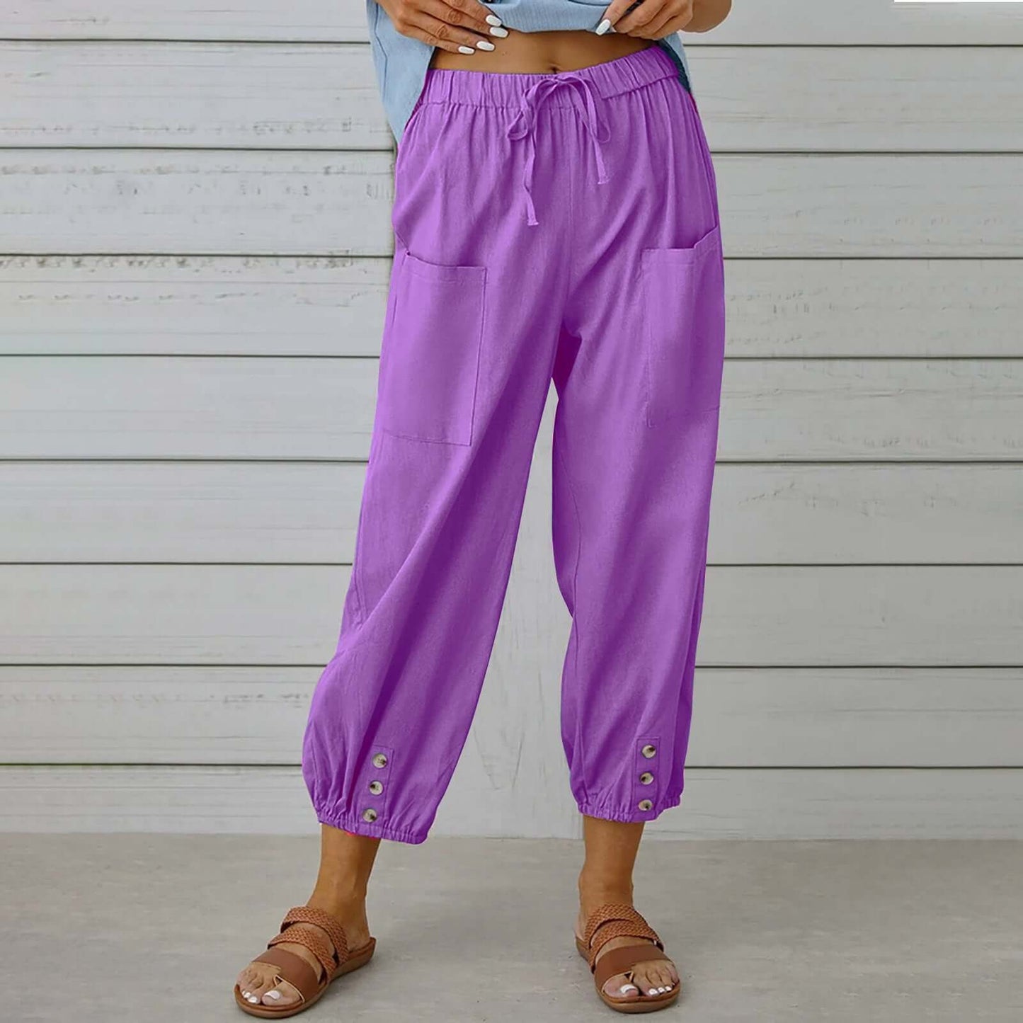 Woman wearing breathable purple Ladies Linen Trousers, featuring comfy pockets and cuff details, perfect for casual wear in all sizes.