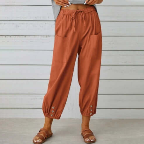 Woman wearing brown Ladies Linen Trousers with drawstring waist and ankle button detail, perfect blend of comfort and style.