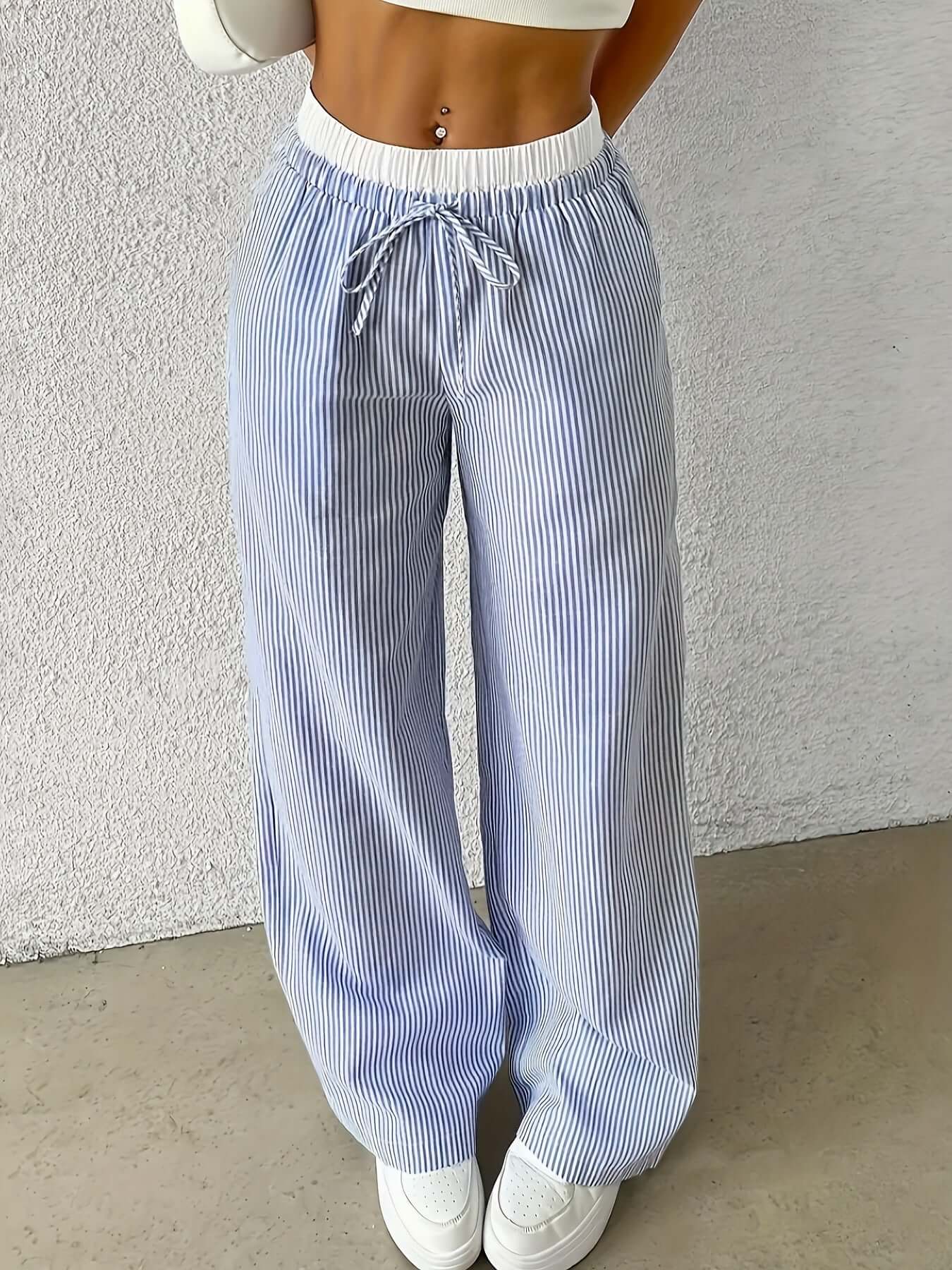 Woman wearing light blue ladies stripe trousers featuring a drawstring waist, perfect for a stylish and comfortable look.