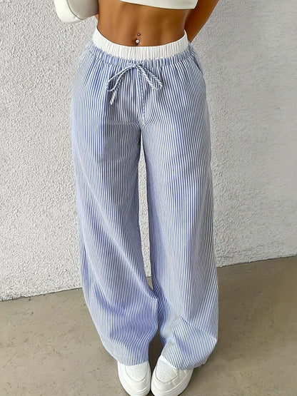 Woman wearing light blue ladies stripe trousers featuring a drawstring waist, perfect for a stylish and comfortable look.