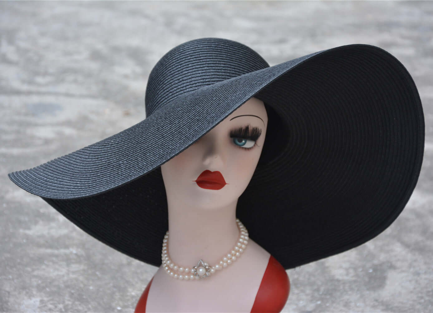 Elegant big straw hat displayed on a mannequin, showcasing sun protection and stylish summer flair.