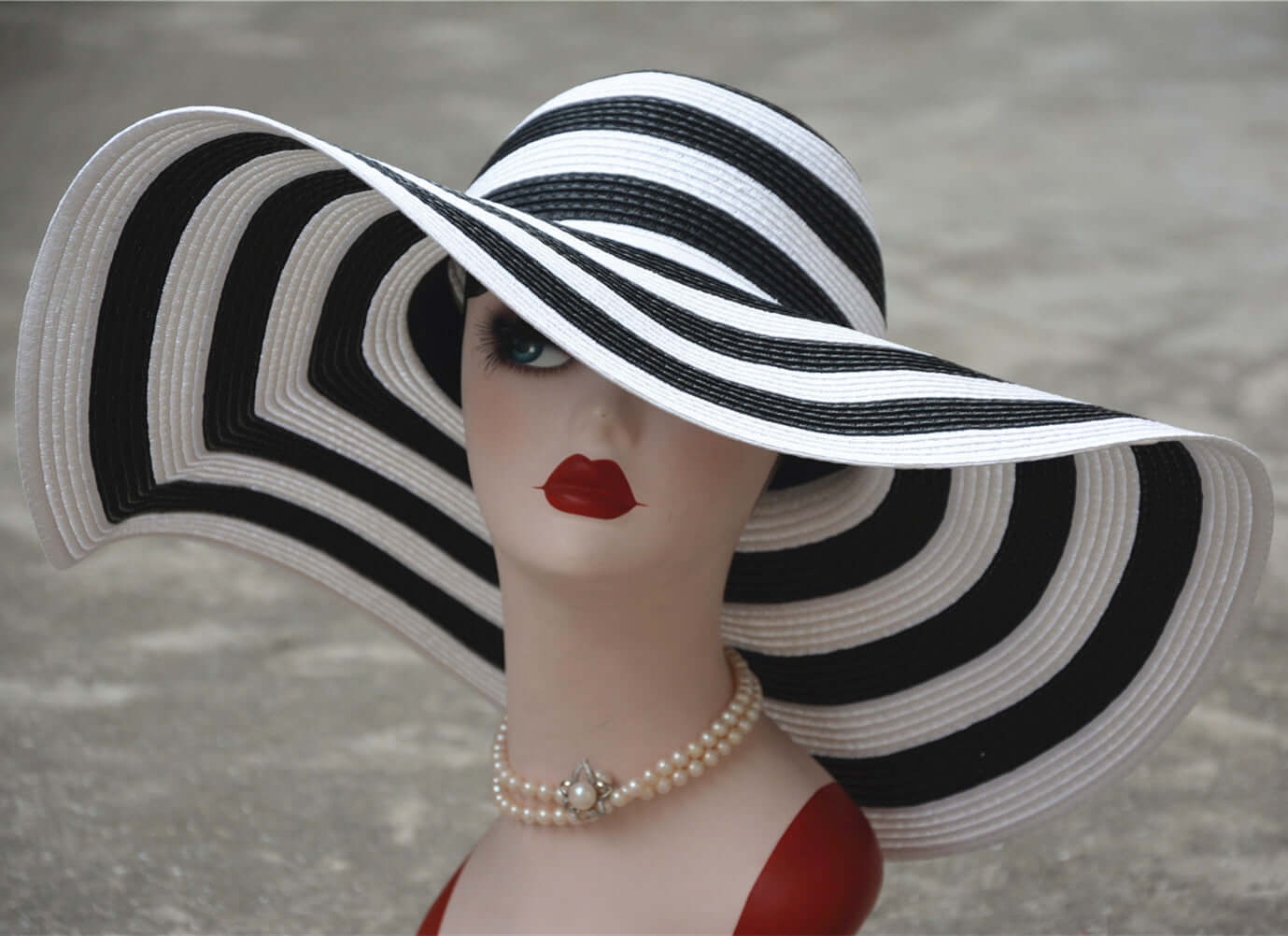 Elegant big straw hat with black and white stripes, perfect for sunny beach days and stylish sun protection.
