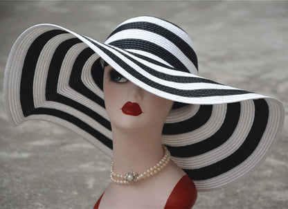 Elegant big straw hat with black and white stripes, perfect for sunny beach days and stylish sun protection.