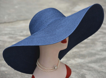 Oversized navy blue straw hat on a mannequin, showcasing elegant sun protection and style for sunny days.