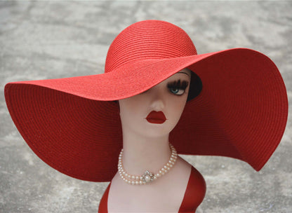 Stylish big straw hat on a mannequin with a bold red design, perfect for sunny days at the beach or park.