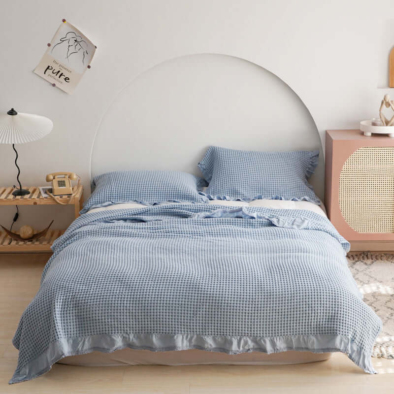 Stylish blue plaid quilt set on a neatly made bed, enhancing bedroom comfort and aesthetics.