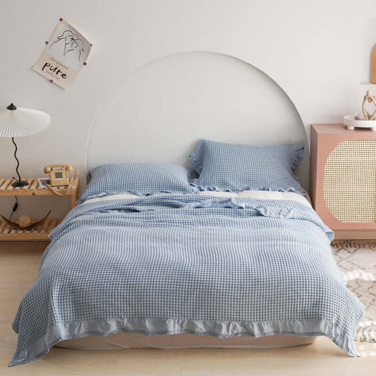 Stylish blue plaid quilt set on a neatly made bed, enhancing bedroom comfort and aesthetics.
