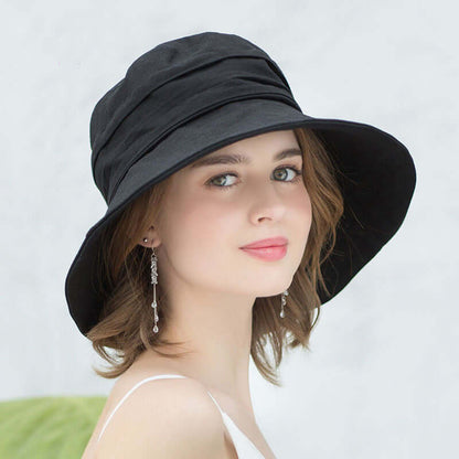 Stylish woman wearing a black Bucket Cap Hat, perfect for sun protection and fashionable adventures.