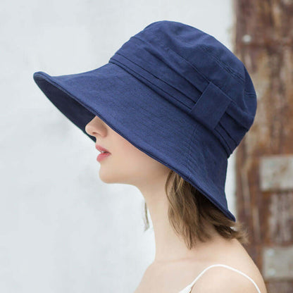 Profile view of a woman wearing a stylish navy Bucket Cap Hat, showcasing its wide brim and modern design.