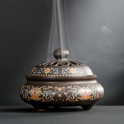 Elegant ceramic incense burner with intricate designs, releasing aromatic smoke for tranquility and style.