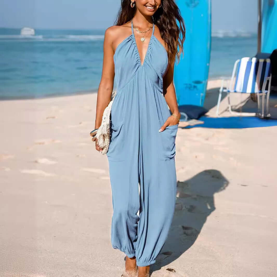 Woman wearing a light blue Back Open Jumpsuit on a beach, showcasing its stylish open-back design and comfortable fit.