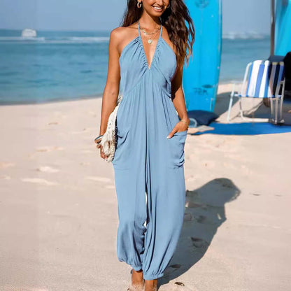 Woman wearing a light blue Back Open Jumpsuit on a beach, showcasing its stylish open-back design and comfortable fit.