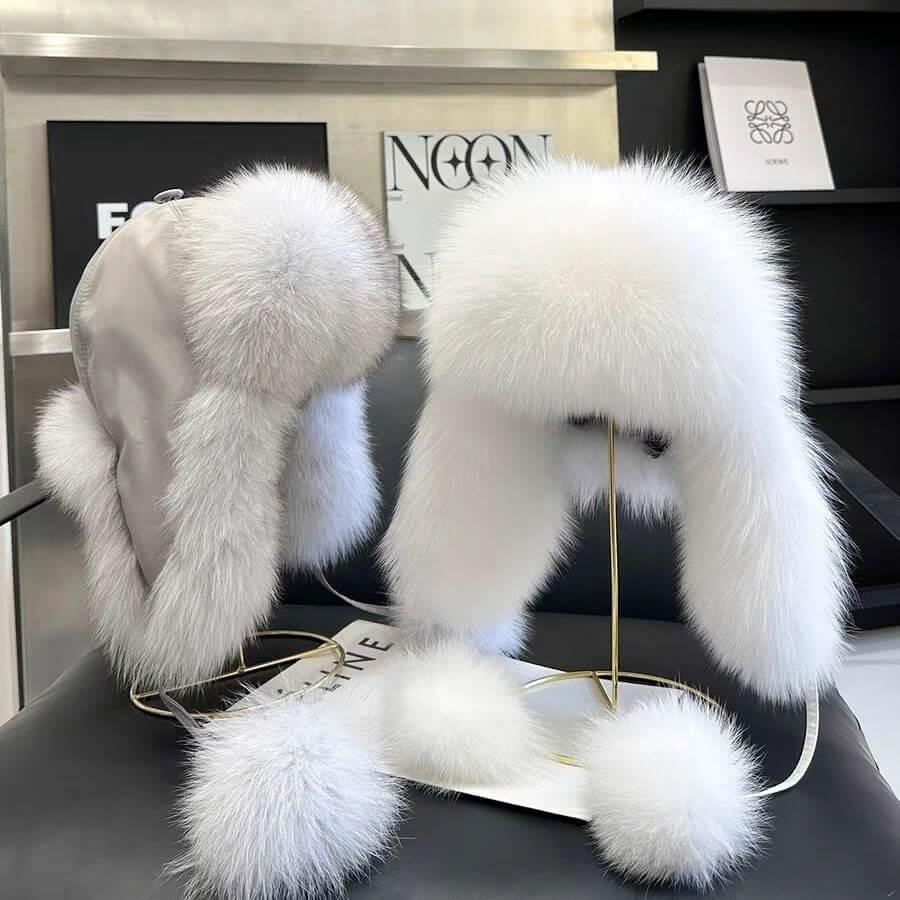 Elegant Ushanka Fur Hats displayed on a stand, showcasing their luxurious white fur and stylish design for winter fashion.