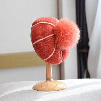 Cozy and stylish beanie with fur ball on display, perfect for winter fashion.