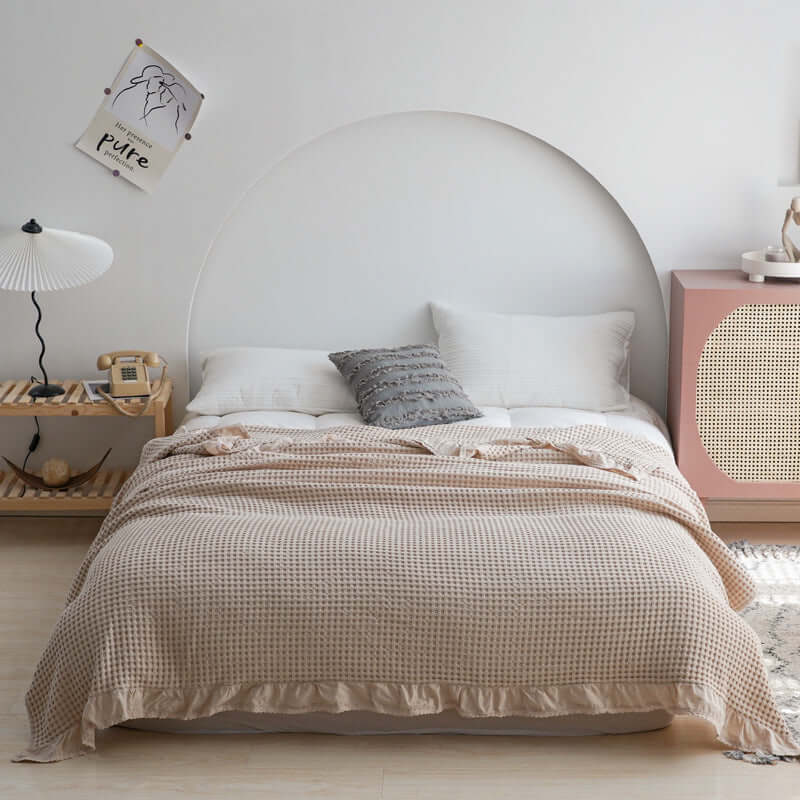Elegant bedroom featuring a cozy plaid quilt on a styled bed with modern decor.