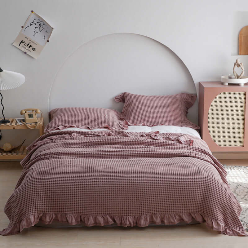 Cozy plaid quilt displayed on a bed with ruffled edges, enhancing a stylish bedroom decor.