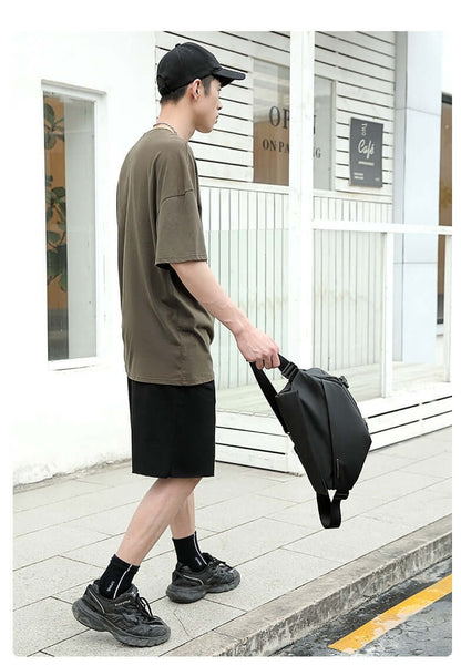 Man carrying Crossbody Multifunctional Bag in urban setting, showcasing sleek design and solid color. Ideal for everyday use.