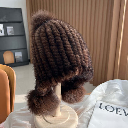Stylish brown Ear Muffs Hat featuring a plush texture and fur pom-poms, perfect for winter warmth and fashion.