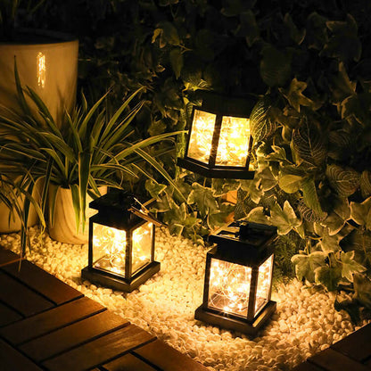 Three wind up lanterns lighting up a wooden deck, ideal for camping or garden retreats.