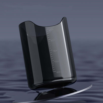 Sleek transparent beaker with measurements on smooth water surface.