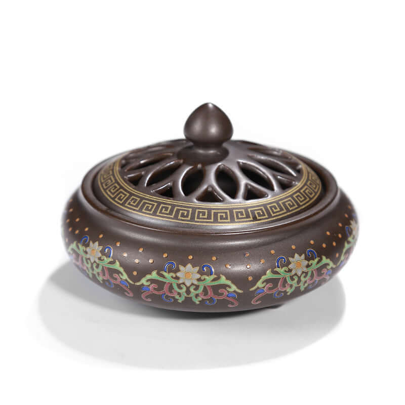 Elegant ceramic incense burner featuring intricate floral designs and a vented lid for enhanced functionality.