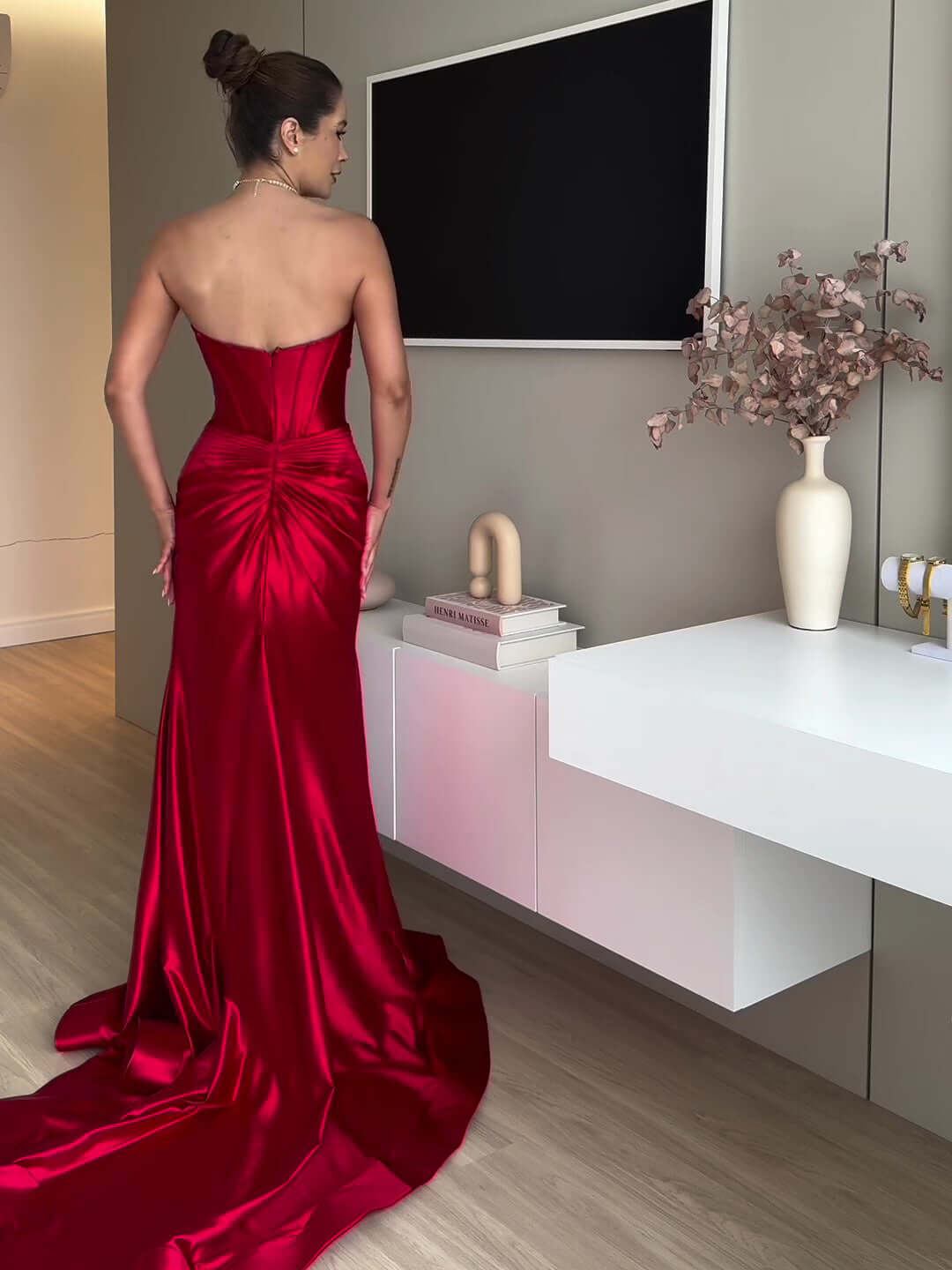 Woman wearing a vibrant red extra long evening gown made of luxurious polyester, ideal for formal events.